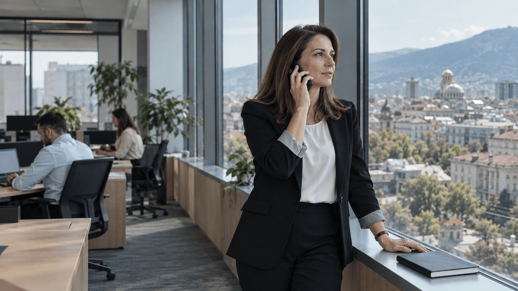 A consultant listening on a phone call by an office window
